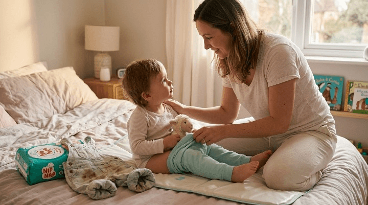 Parent calmly helping a toddler after a potty training accident, wearing pull-up pants toddler style