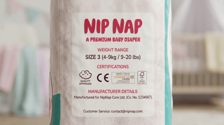 Close-up of a nappy pack showing certification marks and manufacturer details on the back label