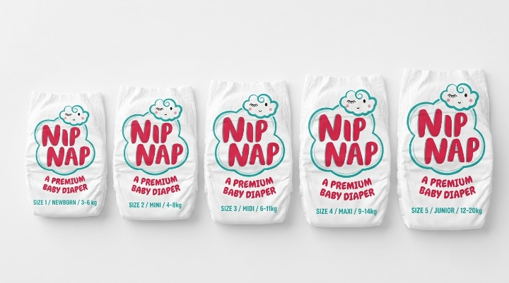 Row of NipNap nappies in different sizes laid out from smallest to largest on a white surface