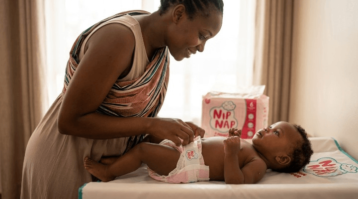 Parent checking a baby's nappy area for signs of rash or allergic reaction